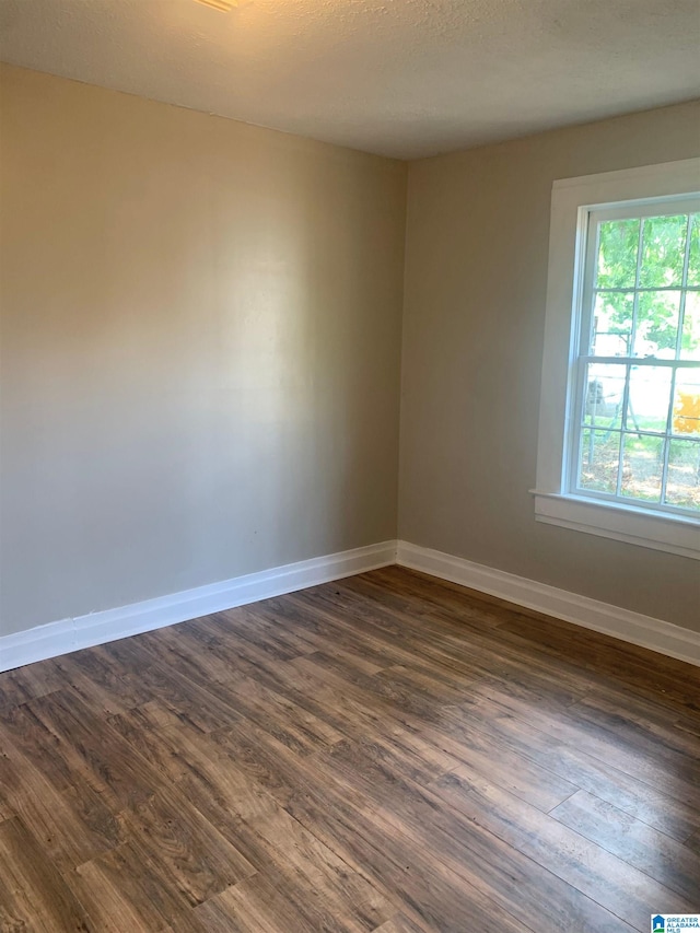 unfurnished room featuring dark hardwood / wood-style floors and a textured ceiling