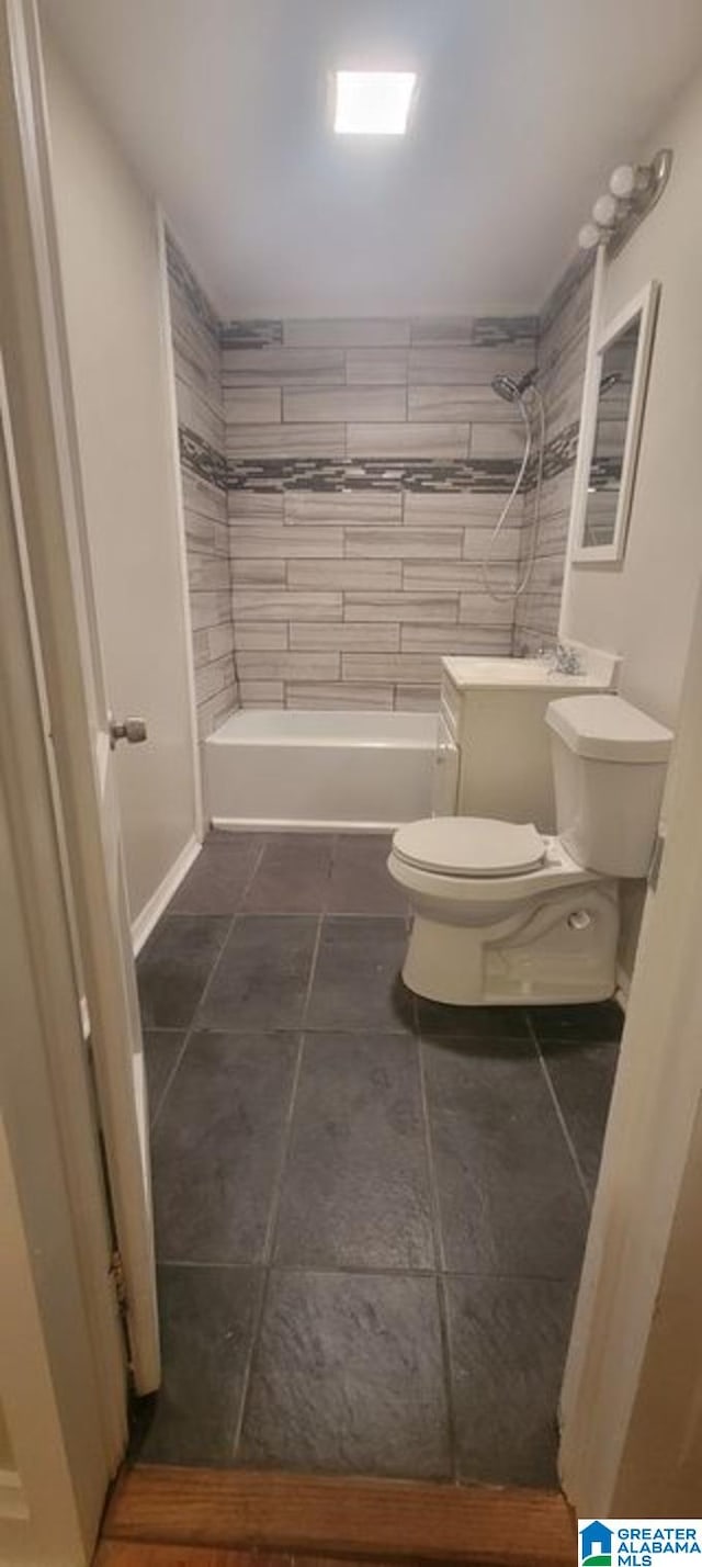 bathroom with a tile shower and toilet