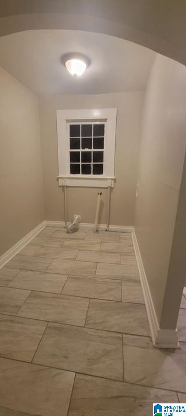 clothes washing area with baseboards