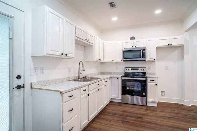 kitchen with appliances with stainless steel finishes, sink, white cabinets, light stone countertops, and dark wood-type flooring