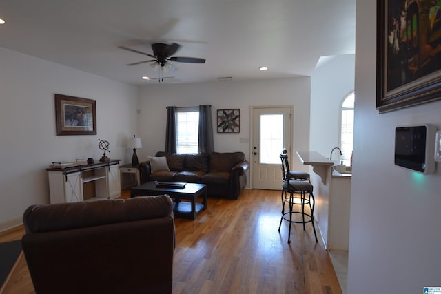 living room with ceiling fan and light hardwood / wood-style flooring