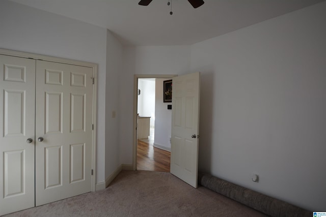 unfurnished bedroom featuring light carpet, ceiling fan, and a closet