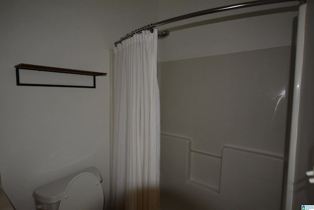 bathroom with a shower with curtain and toilet