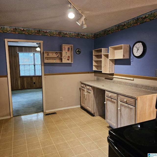 kitchen with light tile patterned flooring, rail lighting, a textured ceiling, and black electric range oven