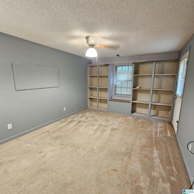 unfurnished room featuring carpet floors, a textured ceiling, and ceiling fan