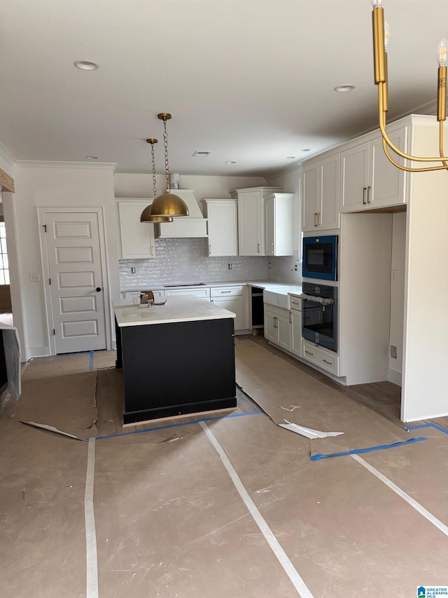 kitchen featuring wall oven, a kitchen island, white cabinetry, light countertops, and pendant lighting