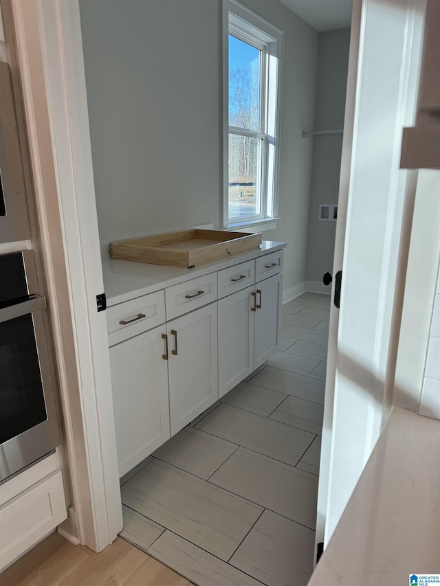 kitchen with stainless steel oven and white cabinets