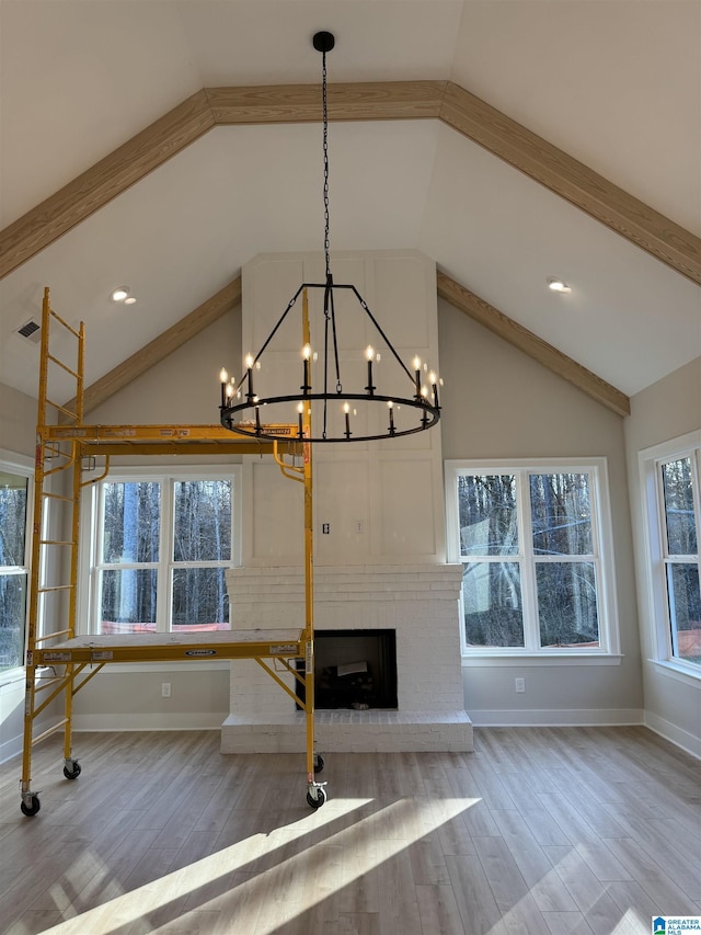 unfurnished living room featuring vaulted ceiling with beams, hardwood / wood-style floors, and a fireplace