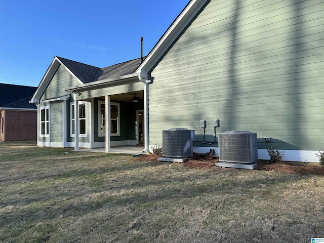 view of property exterior with ceiling fan, central AC unit, and a lawn