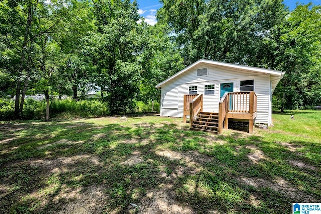 view of front of home with a wooden deck and a front yard