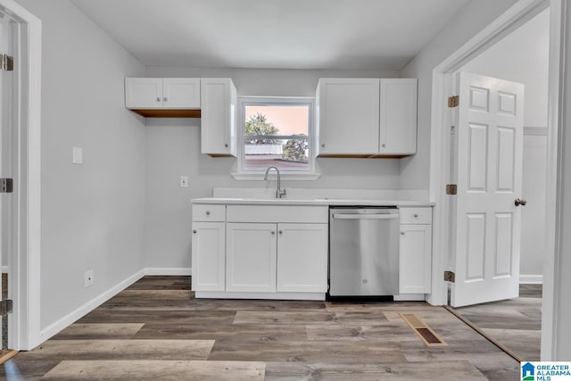 kitchen featuring white cabinetry, stainless steel dishwasher, light hardwood / wood-style floors, and sink