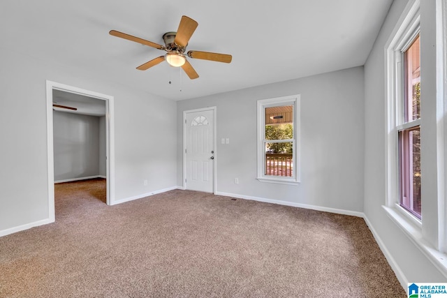 carpeted empty room with a healthy amount of sunlight and ceiling fan