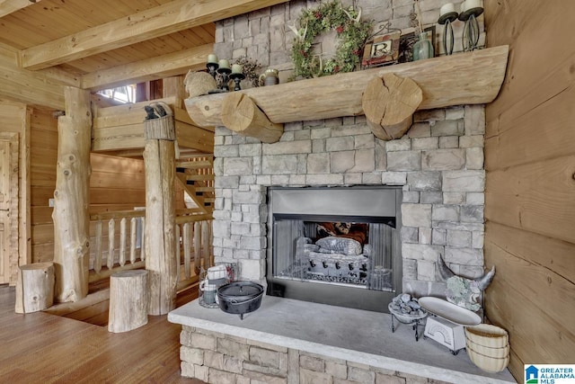 room details with beam ceiling, a fireplace, wooden ceiling, and wood walls