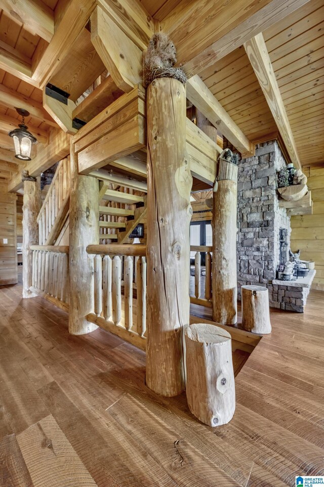 staircase with beamed ceiling, hardwood / wood-style floors, wood ceiling, and wood walls