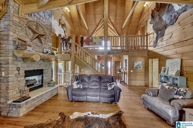 living room featuring beam ceiling, high vaulted ceiling, light hardwood / wood-style flooring, and wooden ceiling