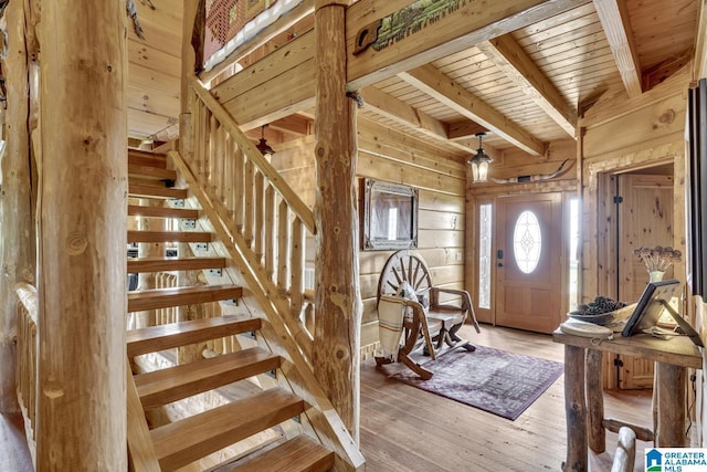 entrance foyer with hardwood / wood-style floors, wood ceiling, beamed ceiling, and wood walls