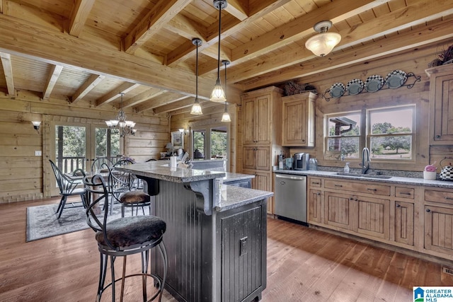 kitchen with sink, decorative light fixtures, dishwasher, and wood walls