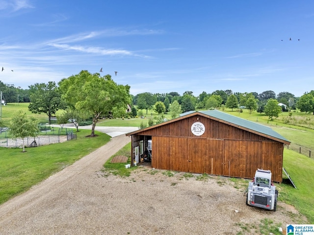 view of outdoor structure with a rural view and a lawn