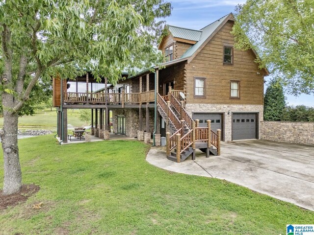 back of house featuring a garage, a wooden deck, a patio area, and a lawn