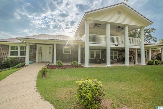 view of front facade featuring a balcony, covered porch, ceiling fan, and a front lawn