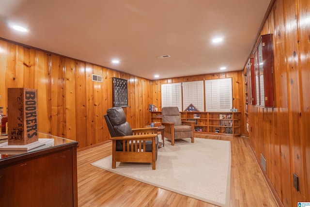 living area featuring wooden walls and light wood-type flooring