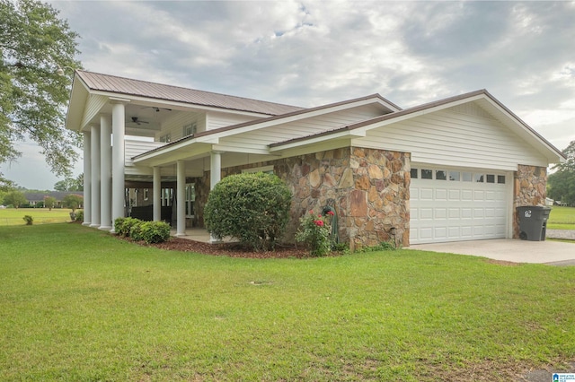 view of front of home featuring a garage, a front lawn, and ceiling fan