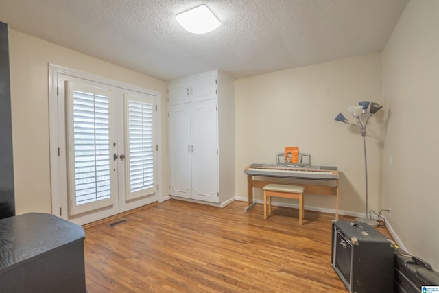 interior space featuring light hardwood / wood-style floors and a textured ceiling