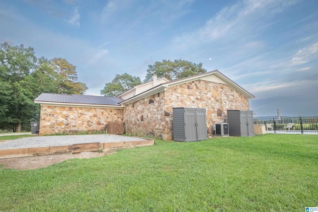 exterior space with central AC and a yard