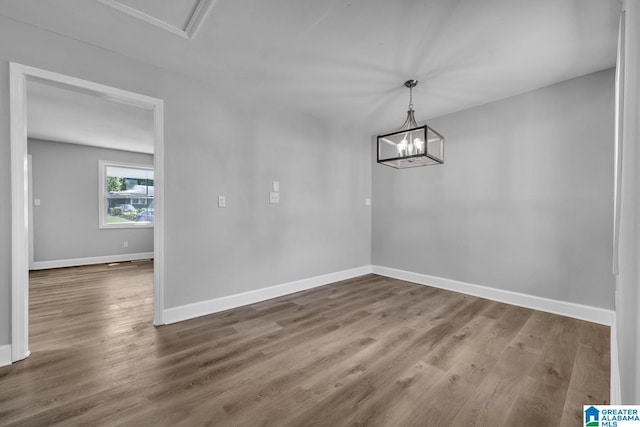 unfurnished dining area with wood-type flooring and a chandelier