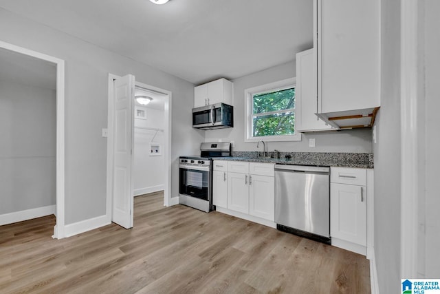 kitchen with sink, light wood-type flooring, stainless steel appliances, and white cabinets