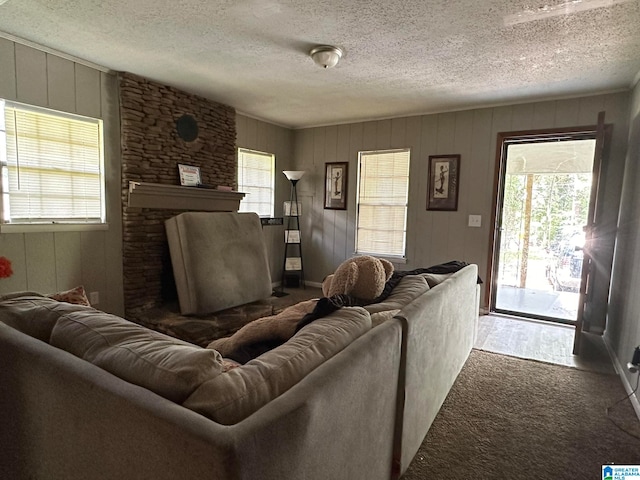 living room with a healthy amount of sunlight, wood walls, and a textured ceiling