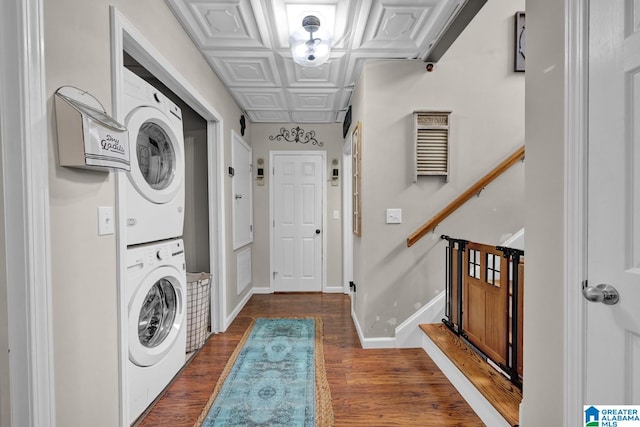 laundry area with stacked washer and clothes dryer and dark hardwood / wood-style floors