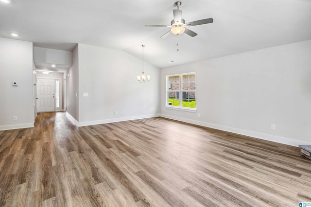 spare room with lofted ceiling, hardwood / wood-style floors, and ceiling fan with notable chandelier