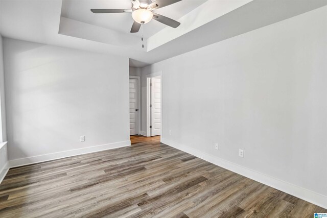 unfurnished living room featuring lofted ceiling, dark wood-type flooring, plenty of natural light, and ceiling fan