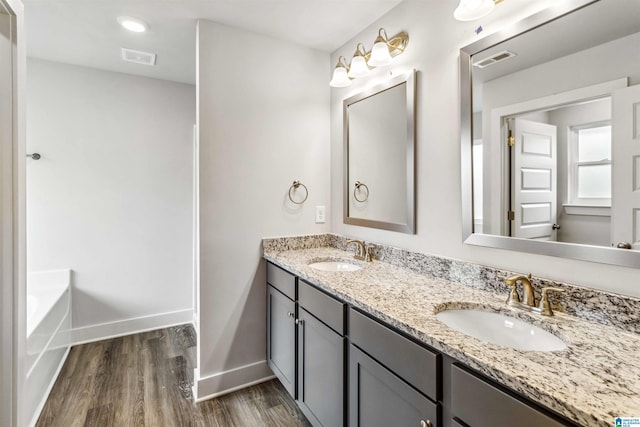 bathroom featuring vanity, hardwood / wood-style floors, and a bathing tub