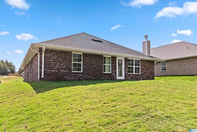 rear view of property featuring a yard