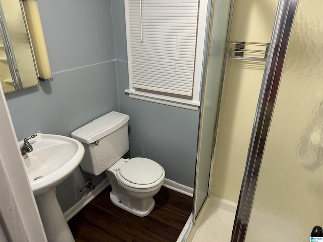 bathroom featuring hardwood / wood-style flooring, toilet, and an enclosed shower