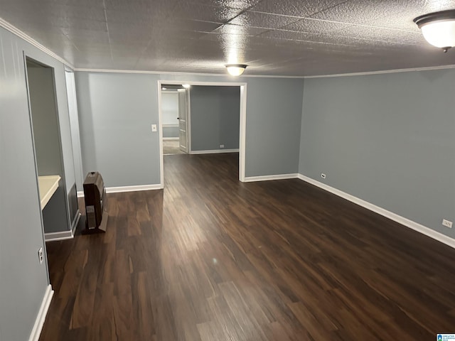 spare room featuring crown molding, dark hardwood / wood-style floors, heating unit, and a textured ceiling