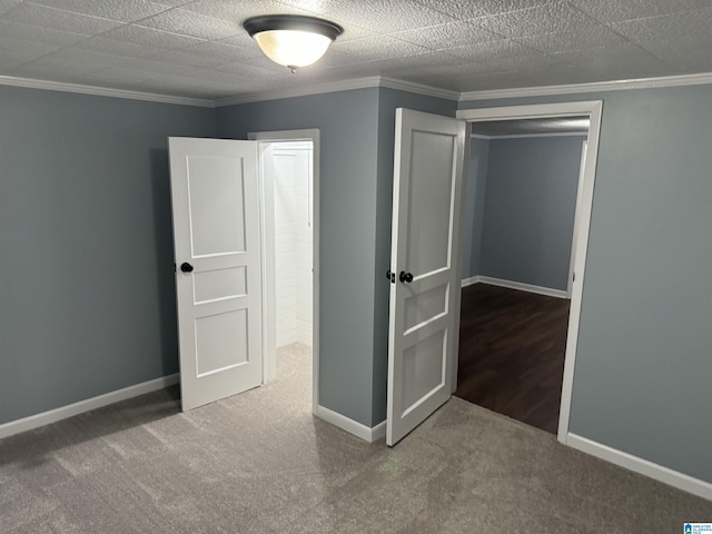 unfurnished bedroom with crown molding, carpet flooring, a textured ceiling, and a closet