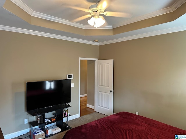 carpeted bedroom featuring ornamental molding, ceiling fan, and a tray ceiling