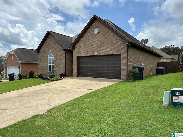 view of front of home with a garage, cooling unit, and a front lawn