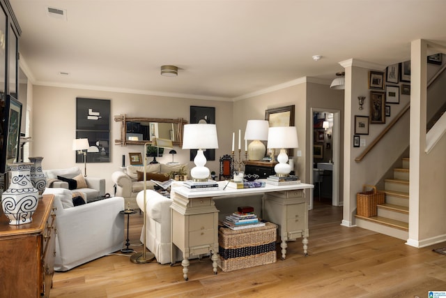 living room with crown molding and light hardwood / wood-style floors