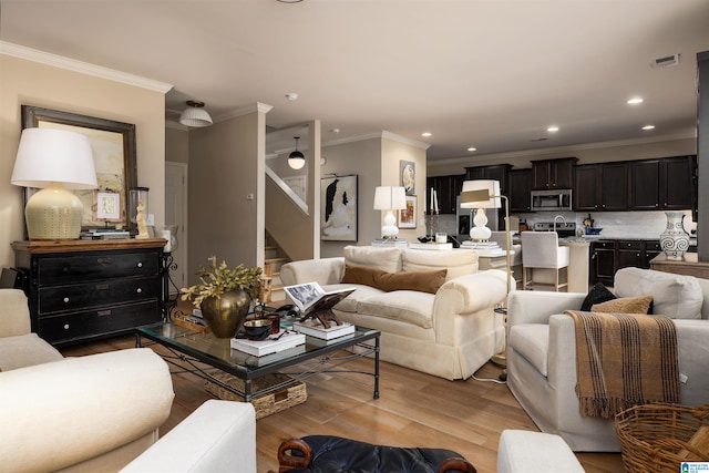 living room with light hardwood / wood-style flooring and ornamental molding