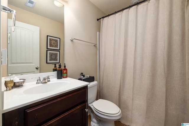 bathroom with vanity, curtained shower, and toilet