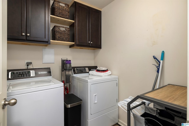 clothes washing area featuring cabinets and washer and dryer