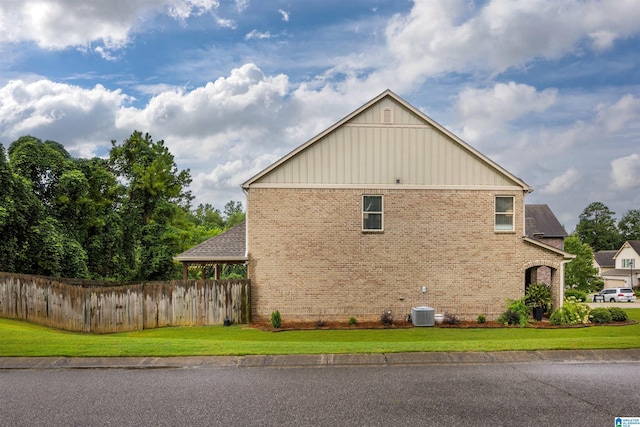 view of home's exterior with cooling unit and a lawn