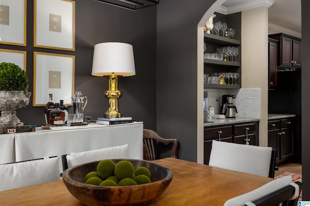 dining area featuring crown molding, bar, and built in features