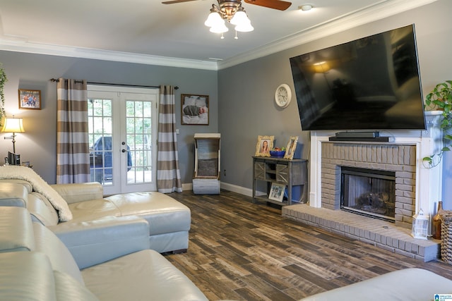 living room featuring ceiling fan, dark hardwood / wood-style floors, a fireplace, ornamental molding, and french doors