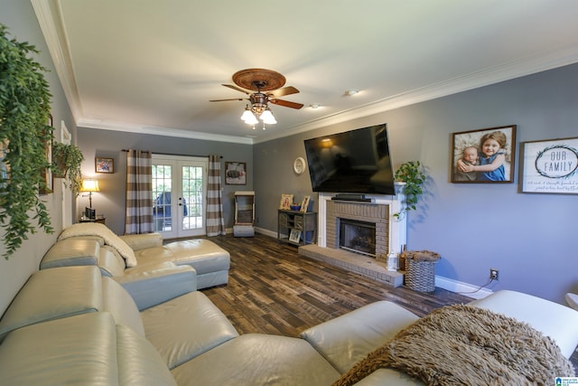 living room featuring french doors, a brick fireplace, ornamental molding, dark hardwood / wood-style floors, and ceiling fan