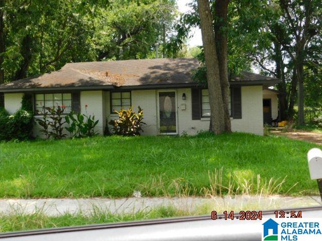 single story home featuring a front lawn